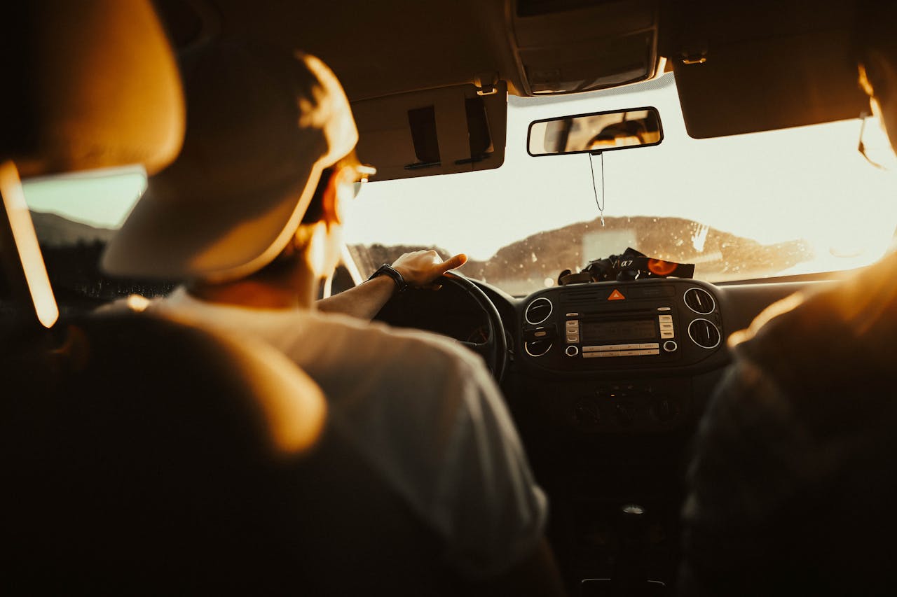 Fahrschüler am Steuer während einer Fahrstunde, Blick von hinten ins Fahrzeuginnere